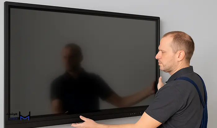 مردی در حال نصب تخته هوشمند